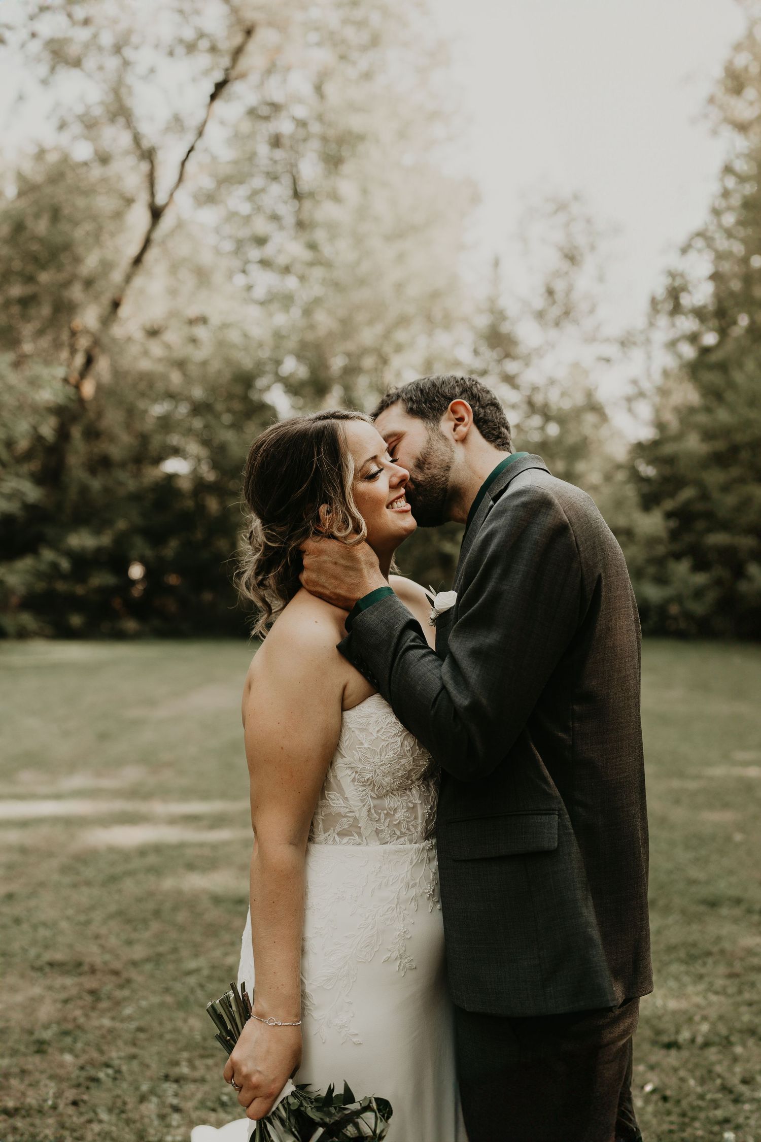 groom kisses bride on cheek