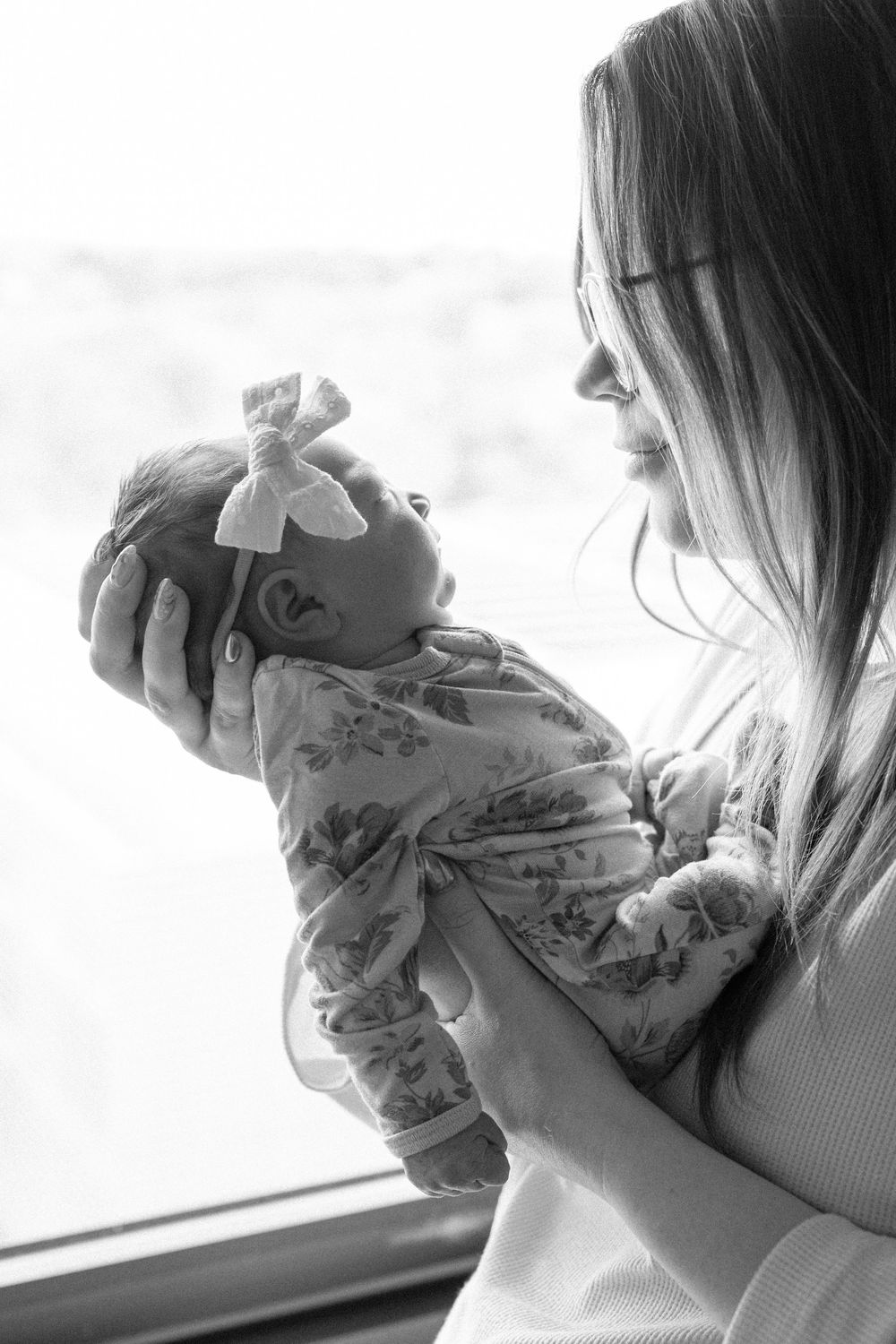 A tender moment captured in black and white showing a parent holding and bonding with their newborn baby.