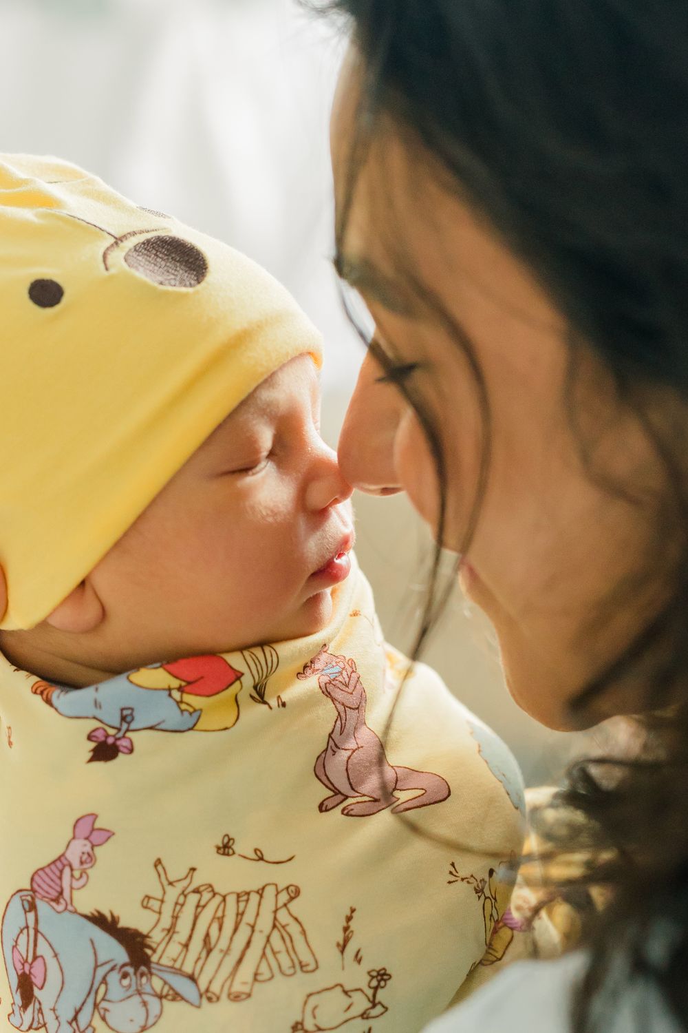 Two people share a tender moment wearing yellow floral print clothing in a close-up shot.