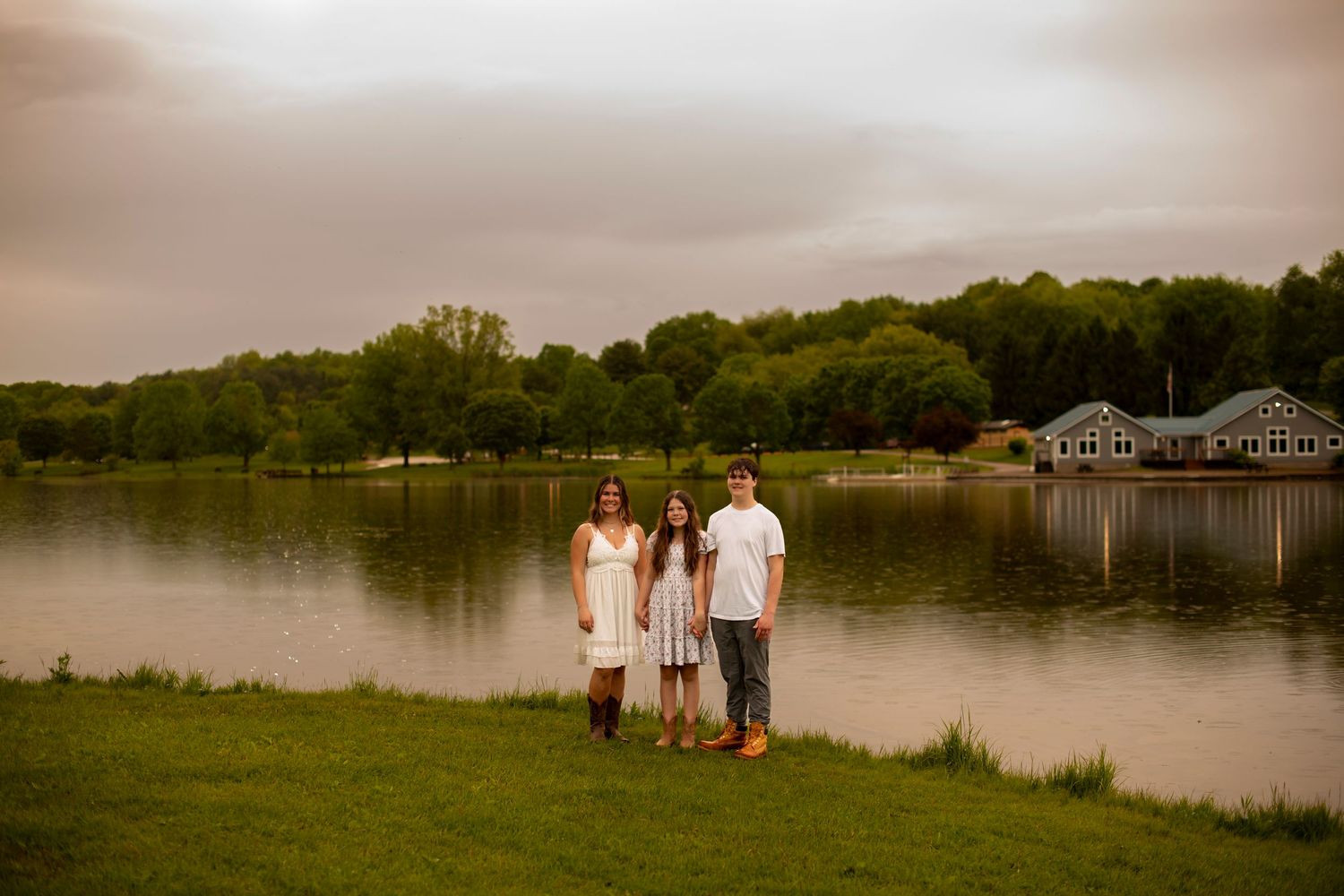 Several connected misty lakeside photos show a serene setting with people in white clothing near a body of water at dusk.