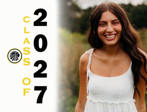 Smiling young woman in white dress poses for Class of 2027 graduation photo outdoors with green background.