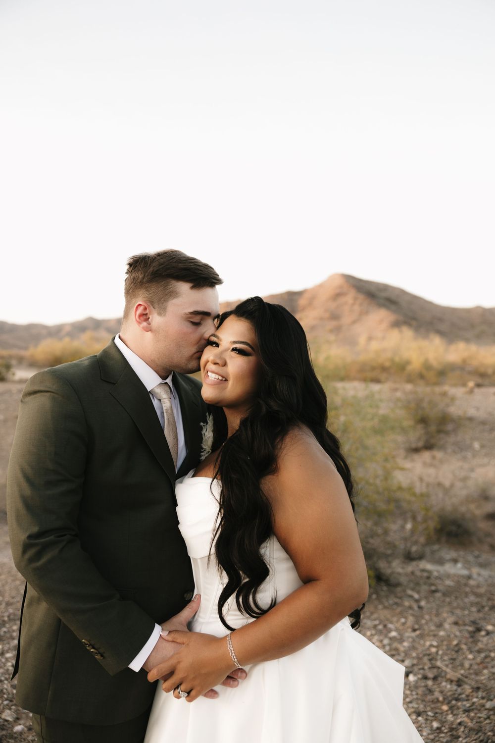 Romantic wedding portrait session with desert mountains in the background at sunset.