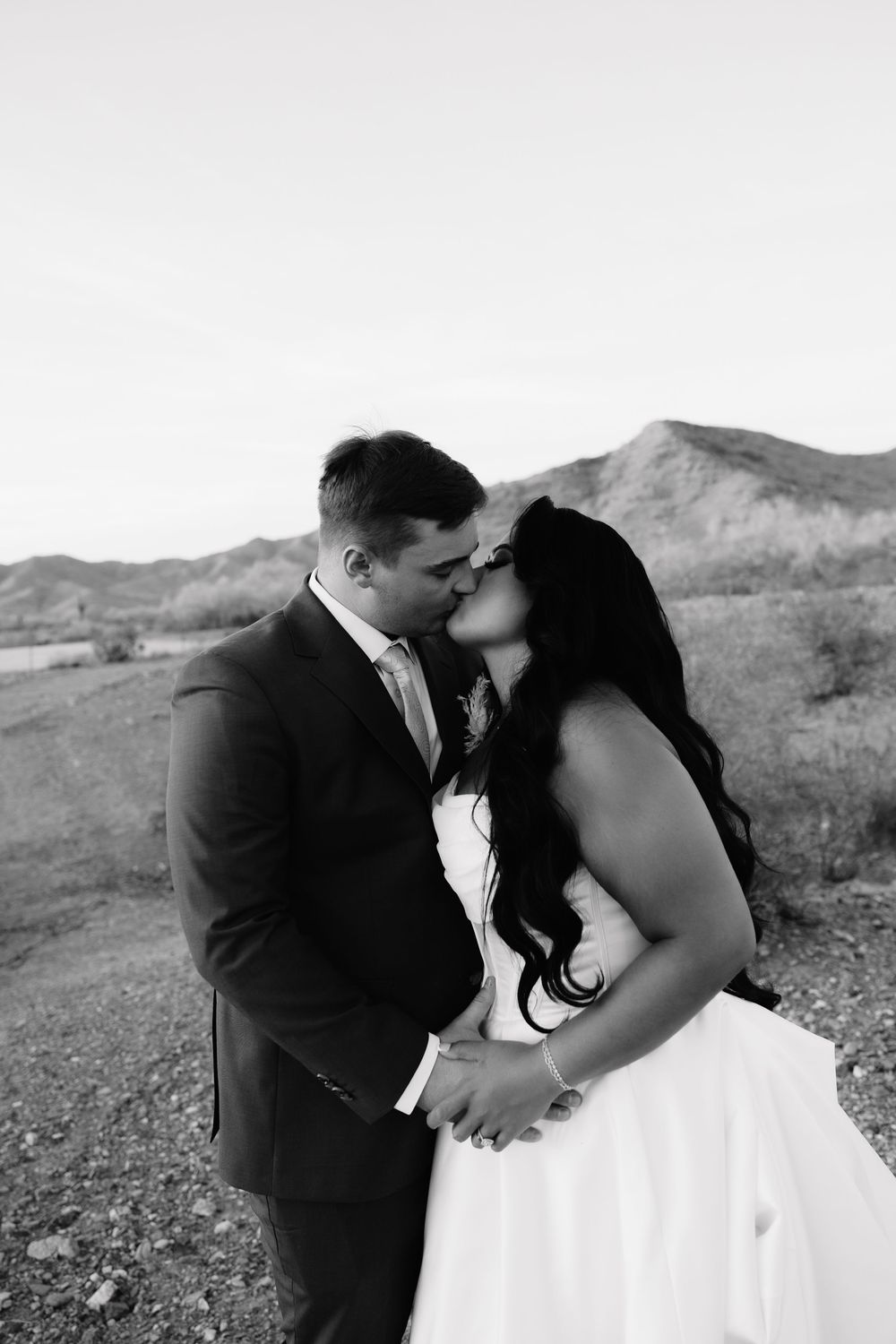 Black and white wedding portraits captured against a desert mountain landscape.