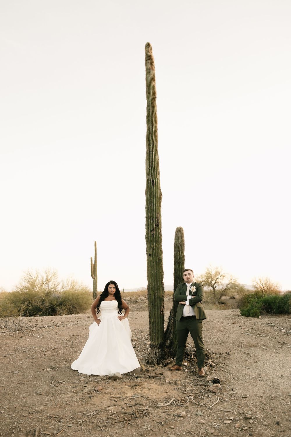 Desert wedding photography session featuring tall saguaro cacti and dramatic poses.