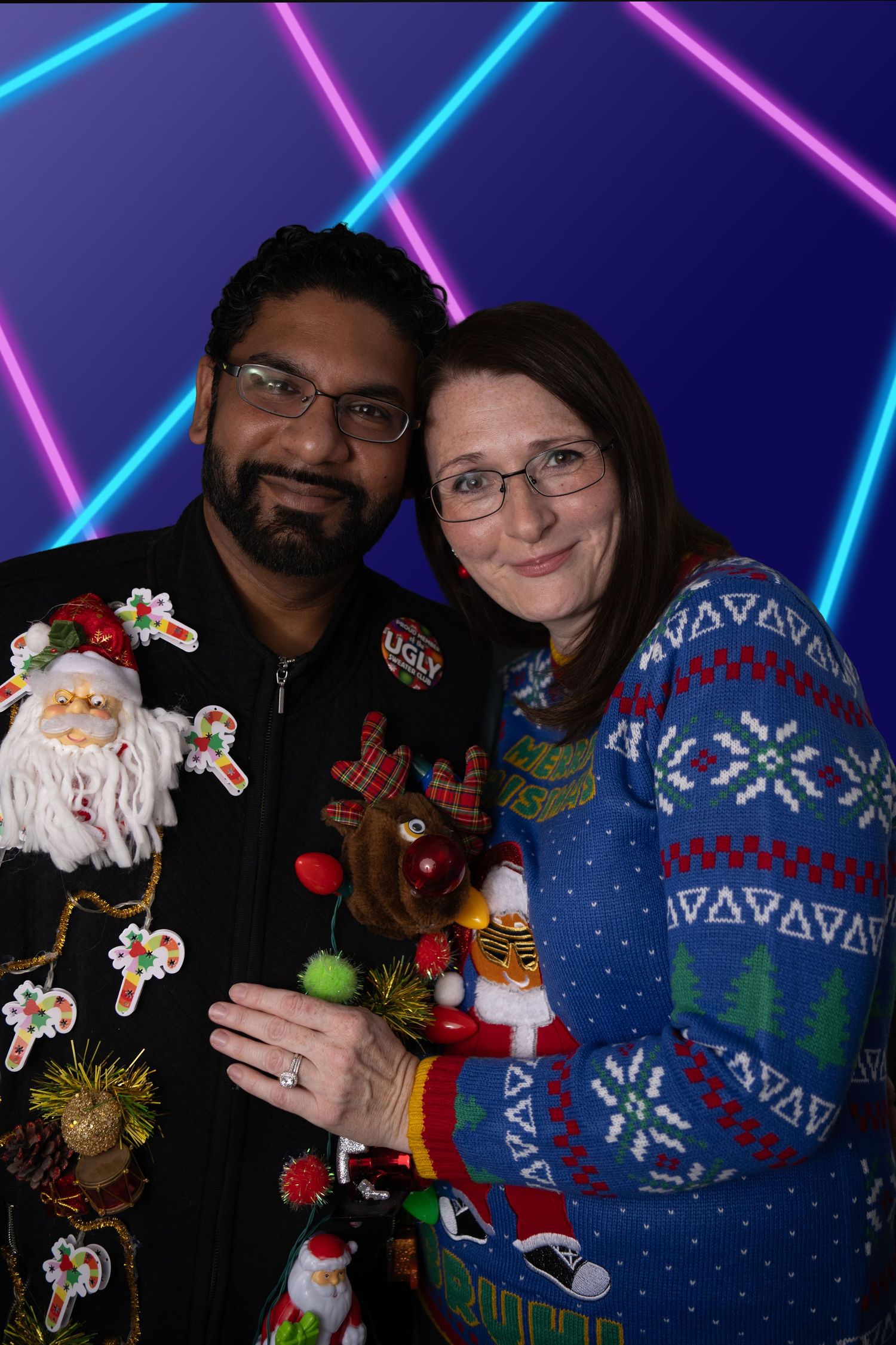 Three people wearing matching blue holiday sweaters in dramatic studio portrait with Nashville family photographer