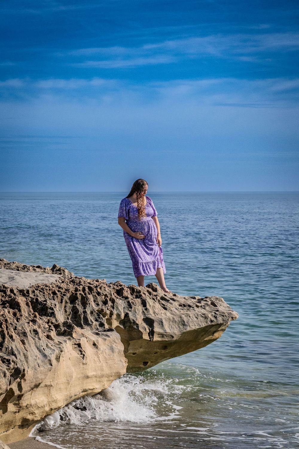 Scenic beach photography session on rocky coastal outcrop with crashing waves.