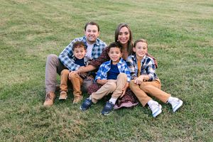 Family of five sitting together on grass during an outdoor Peachtree City family photography session