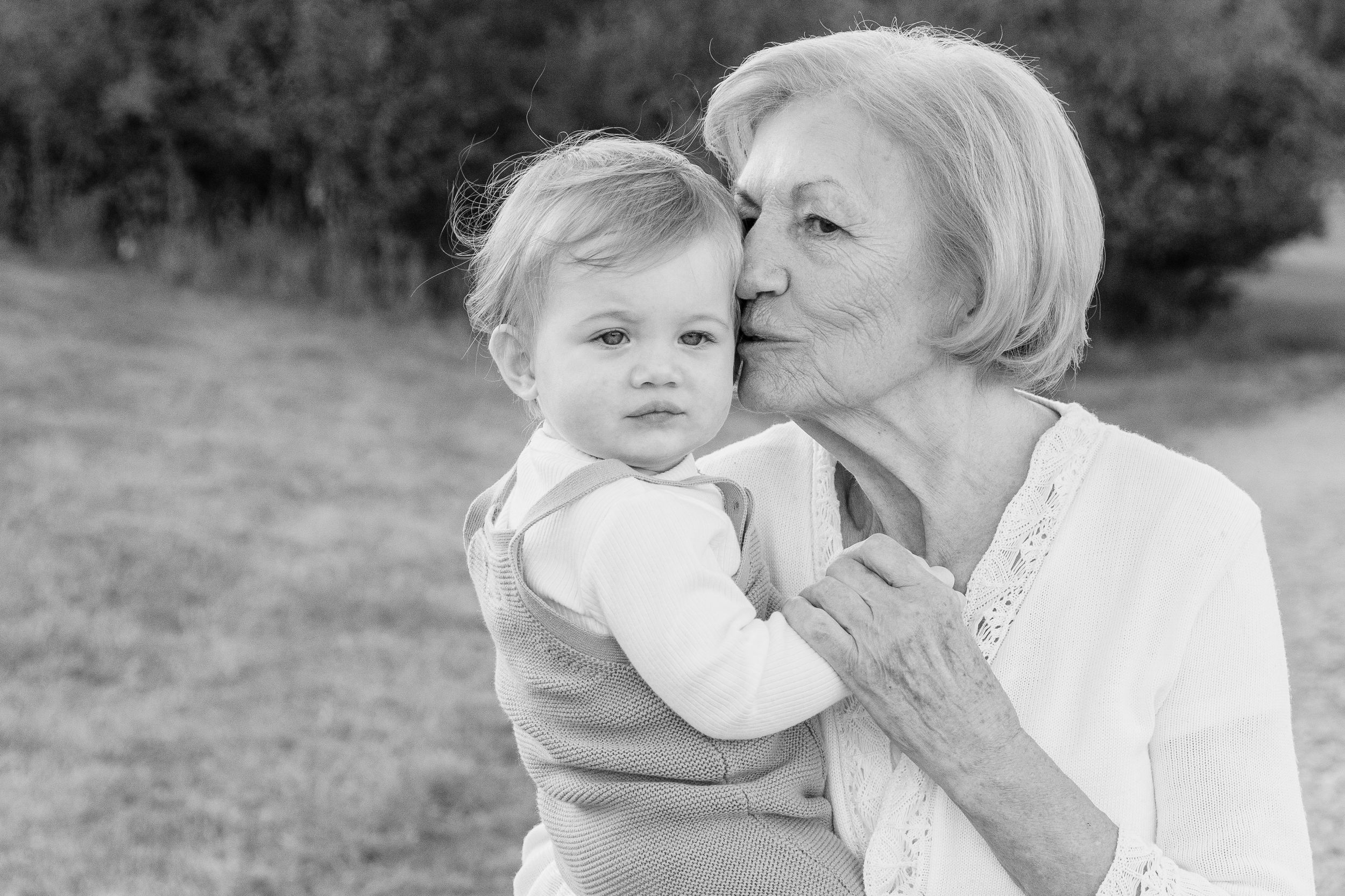 Close-up of a grandmother kissing a baby on the cheek during a family photo session in Peachtree City GA