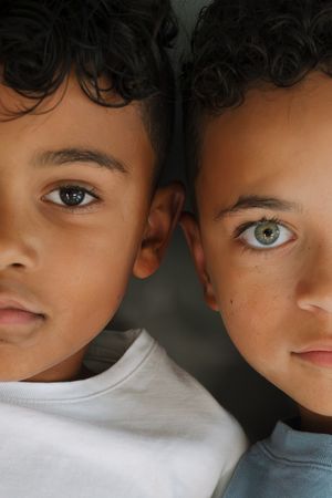 Close-up portrait of two brothers with half of each face side by side