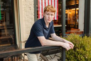 High school senior boy leaning forward during a natural outdoor photography session in Peachtree City, Georgia