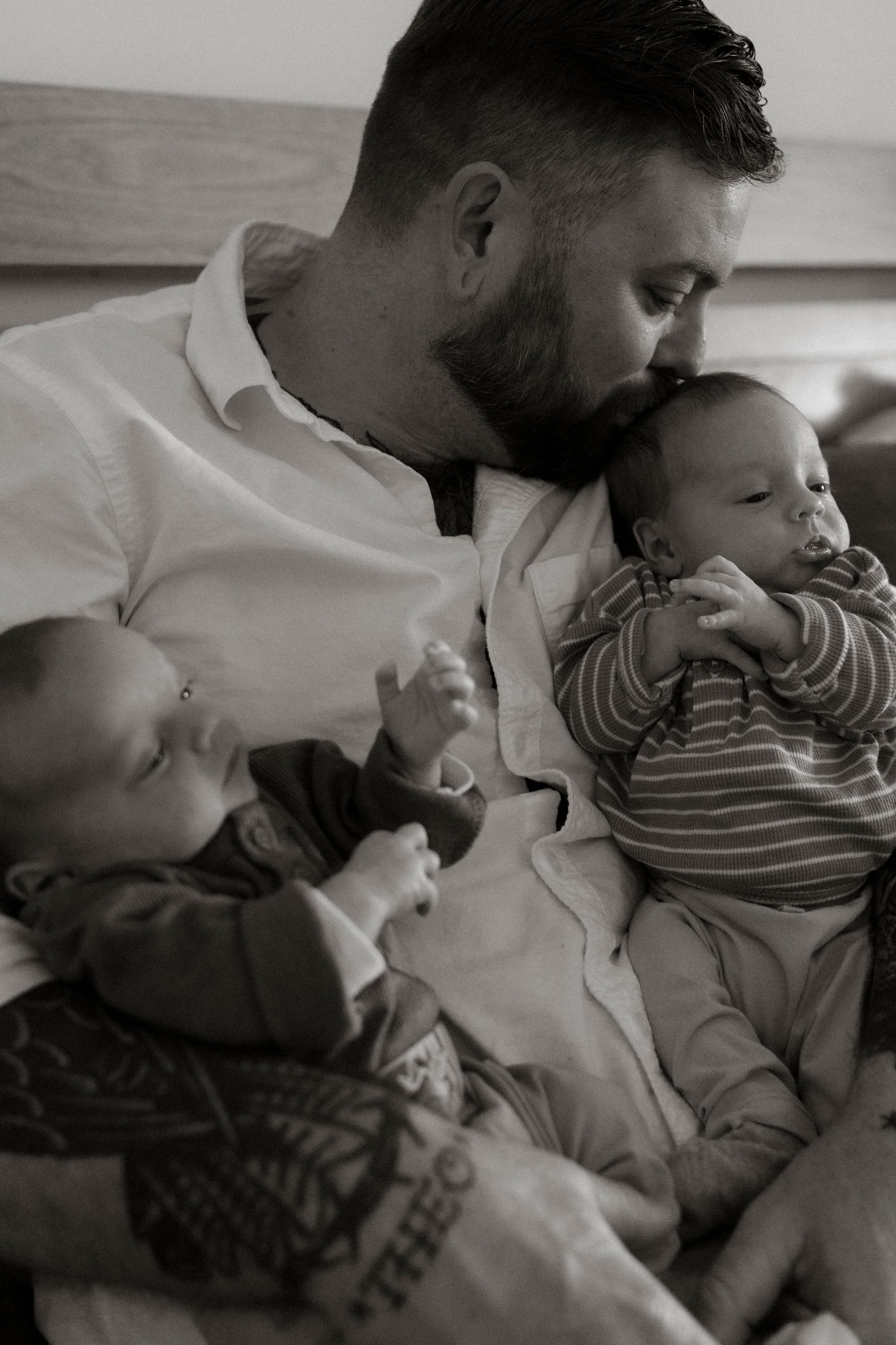 Black and white photo series showing tender moments between parent and baby on a couch.
