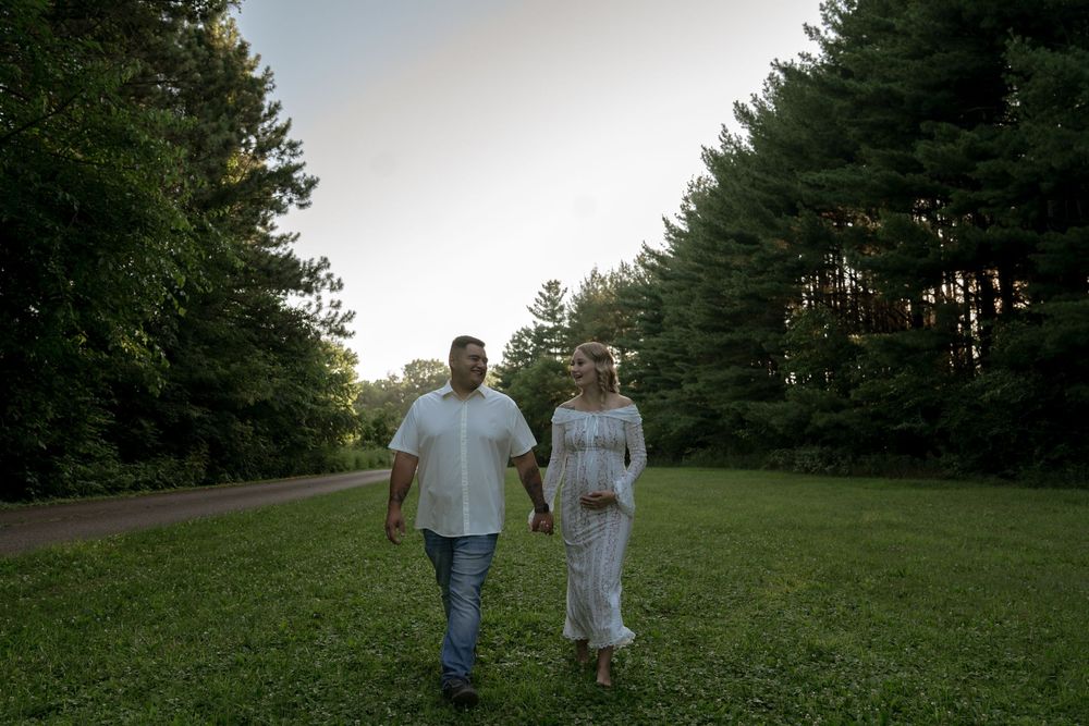 A romantic outdoor photoshoot in a natural setting with trees and grass.