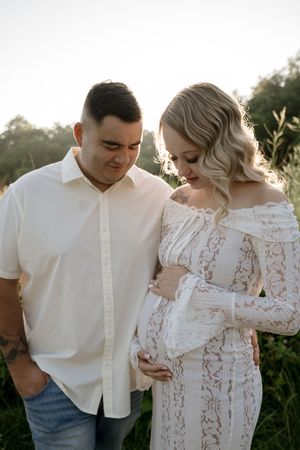 A couple shares tender moments during an outdoor photoshoot at golden hour.