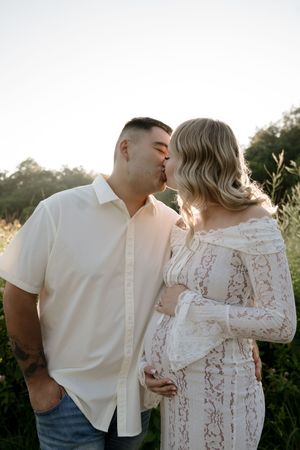 A romantic sunset photoshoot featuring a couple in coordinating white outfits.