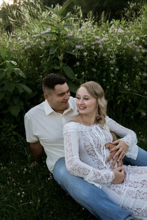 A couple relaxes in a blooming garden during their romantic photoshoot.