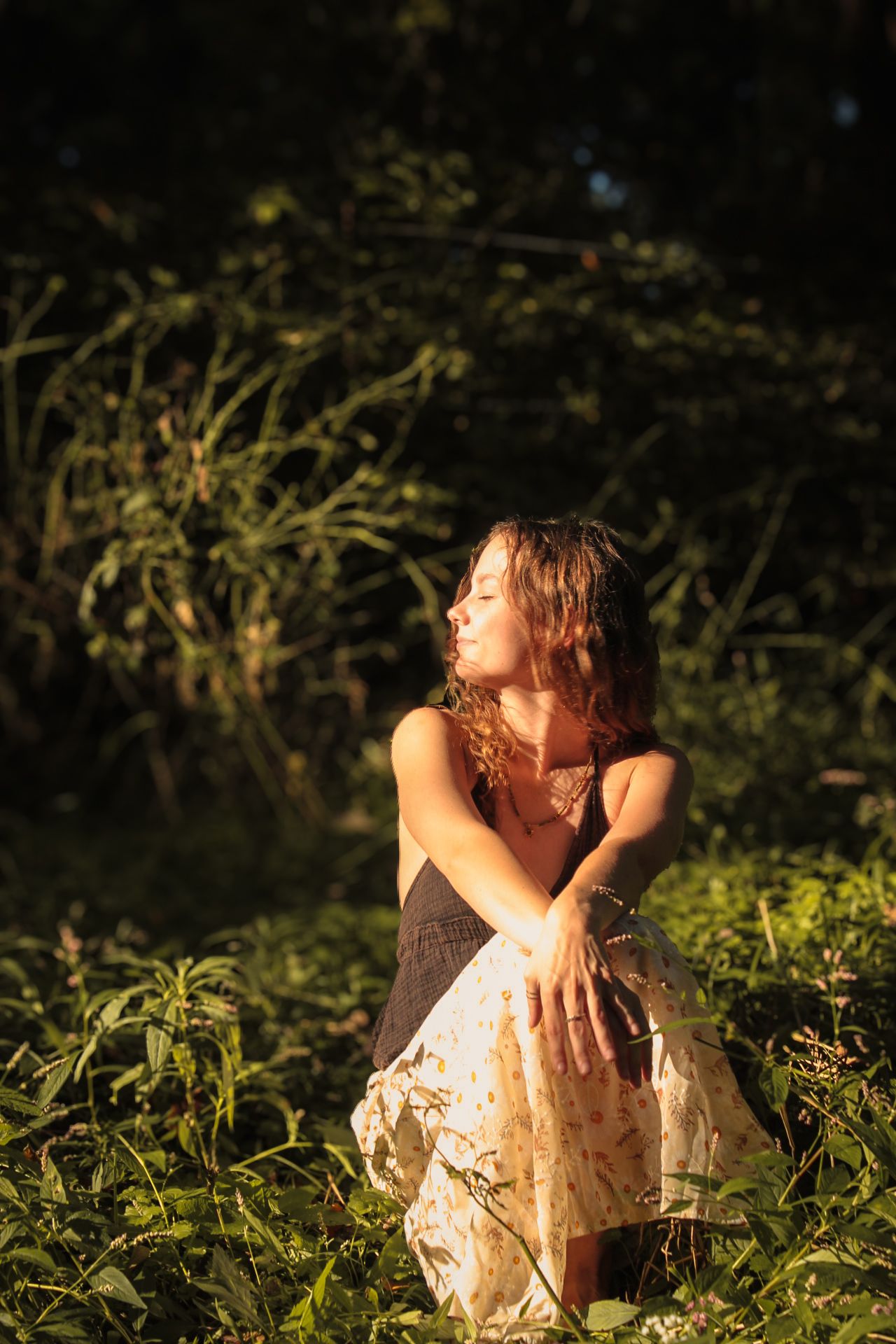 Gracie looking off to the sun with greenery in the background.