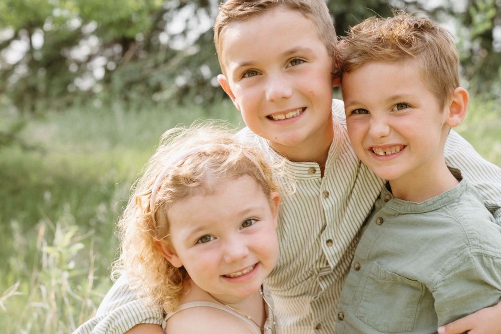 A joyful moment captured outdoors with grassy fields and natural greenery in the background.