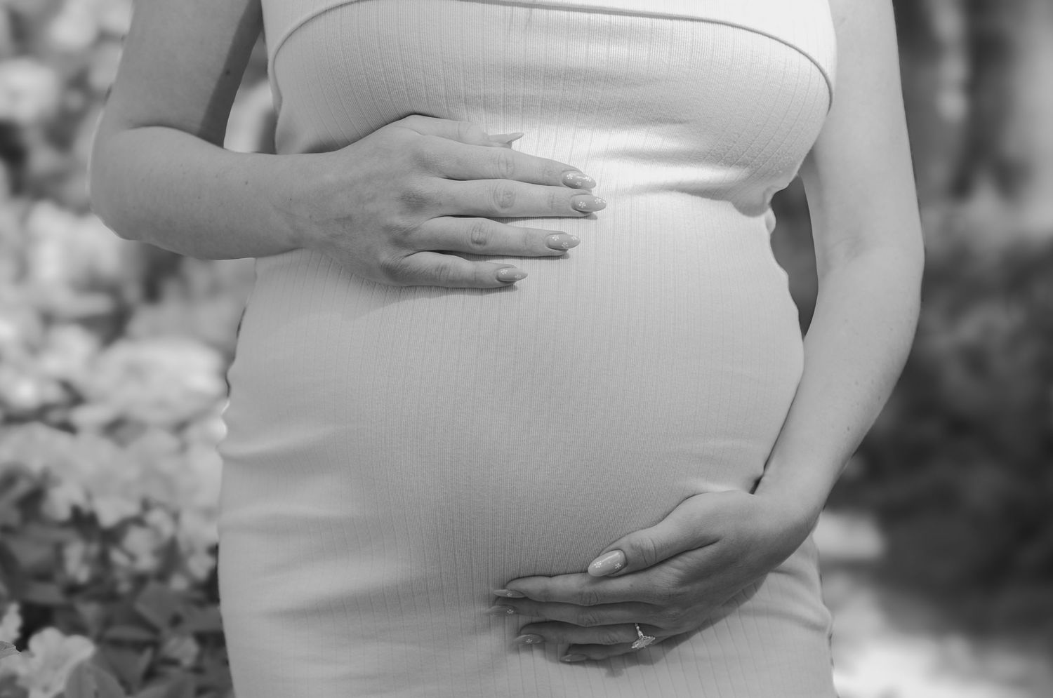 A series of black and white photos showing hands cradling a pregnant belly.