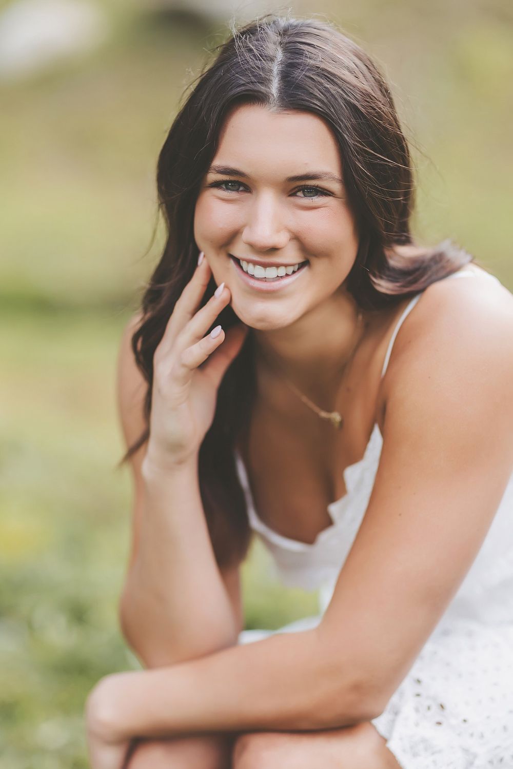 Natural outdoor portrait series with joyful expressions and casual poses in white attire.