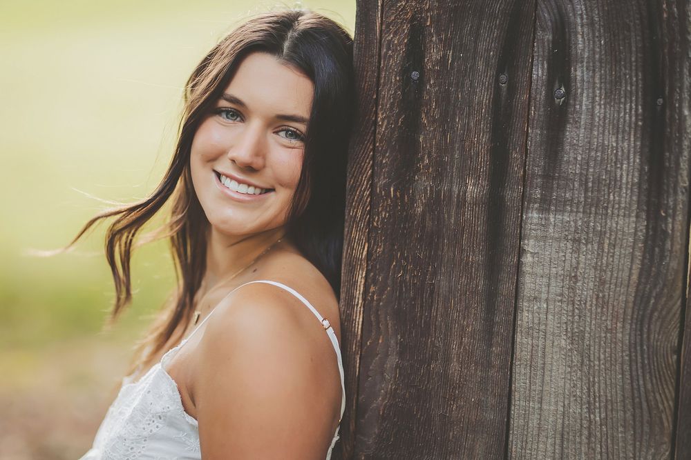 Sun-dappled portraits with natural poses against weathered wood background.