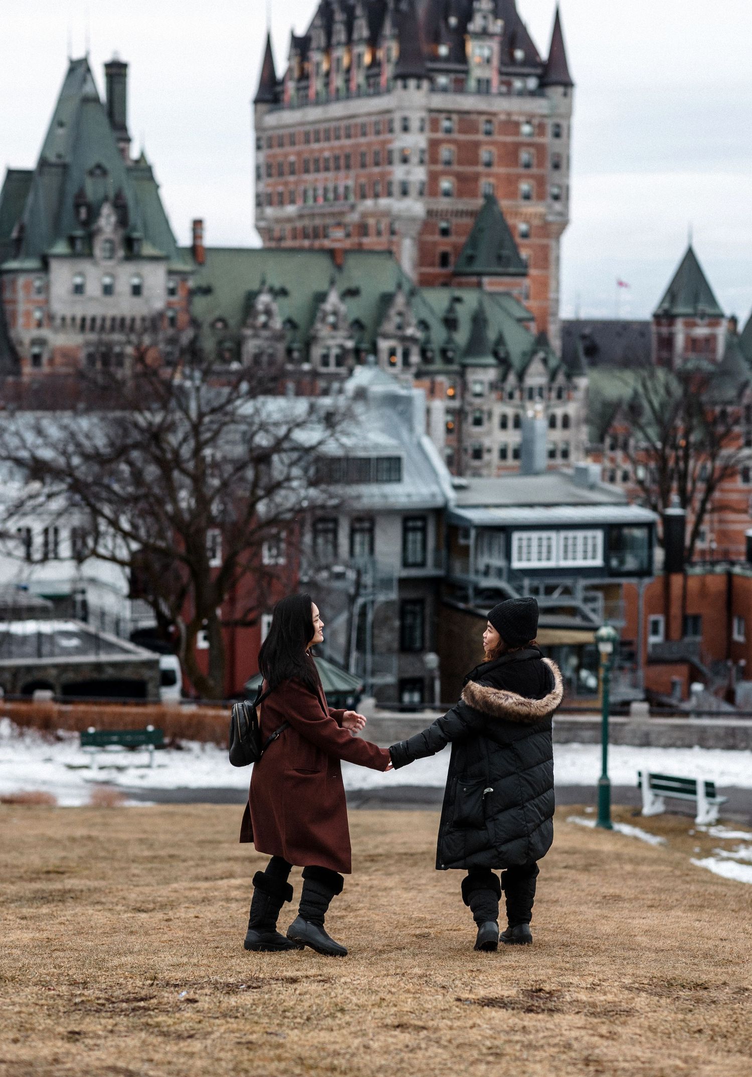Two people dancing together in winter against iconic Chateau Frontenac in Quebec City.