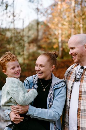 A joyful family moment captured outdoors during fall with warm natural lighting.