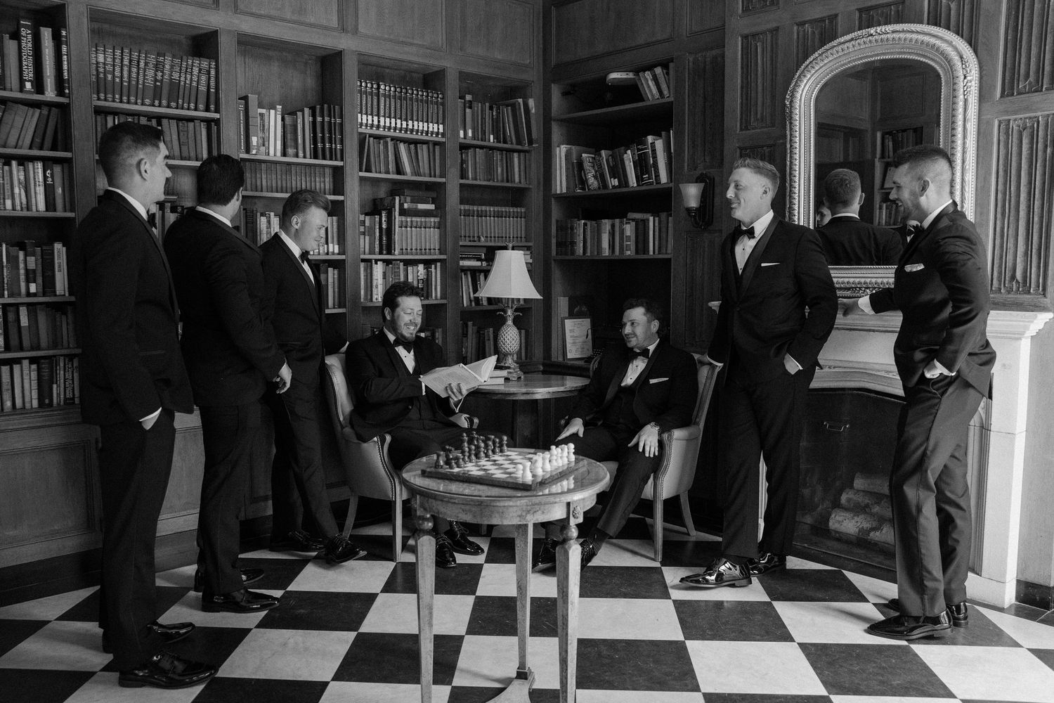 Wedding celebration taking place in an elegant library with dark wood bookshelves.