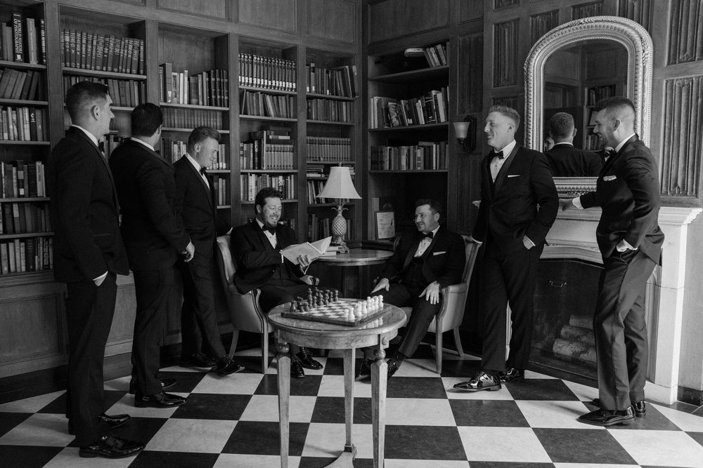 Wedding celebration taking place in an elegant library with dark wood bookshelves.