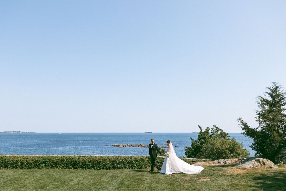 Panoramic view of a coastal wedding ceremony site with ocean and rocky shoreline.