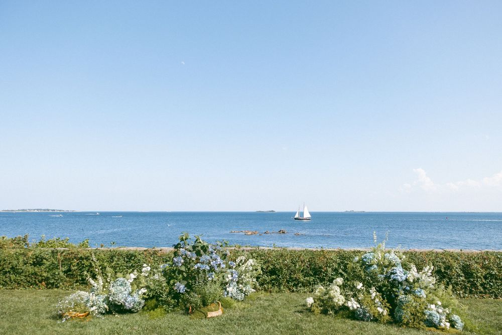 Seaside wedding ceremony setup with white chairs and ocean views.