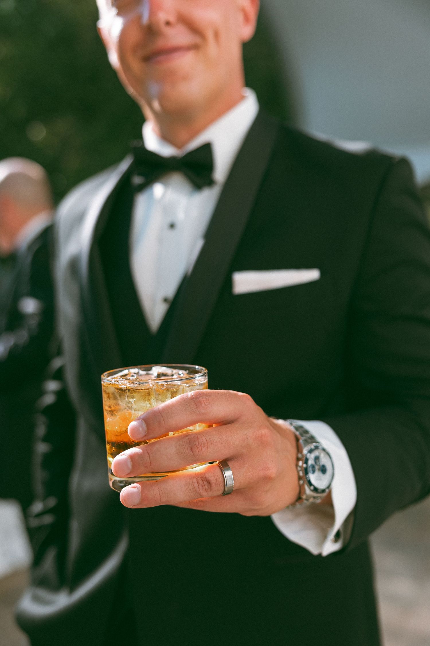 Close-up shots of hands holding cocktail glasses at a formal event.