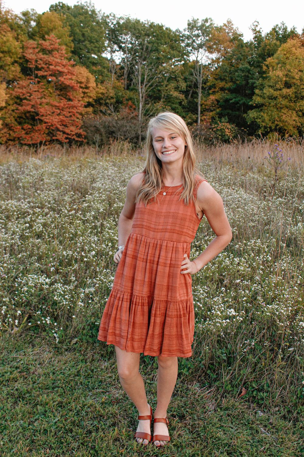 Senior girl in a field during golden hour.