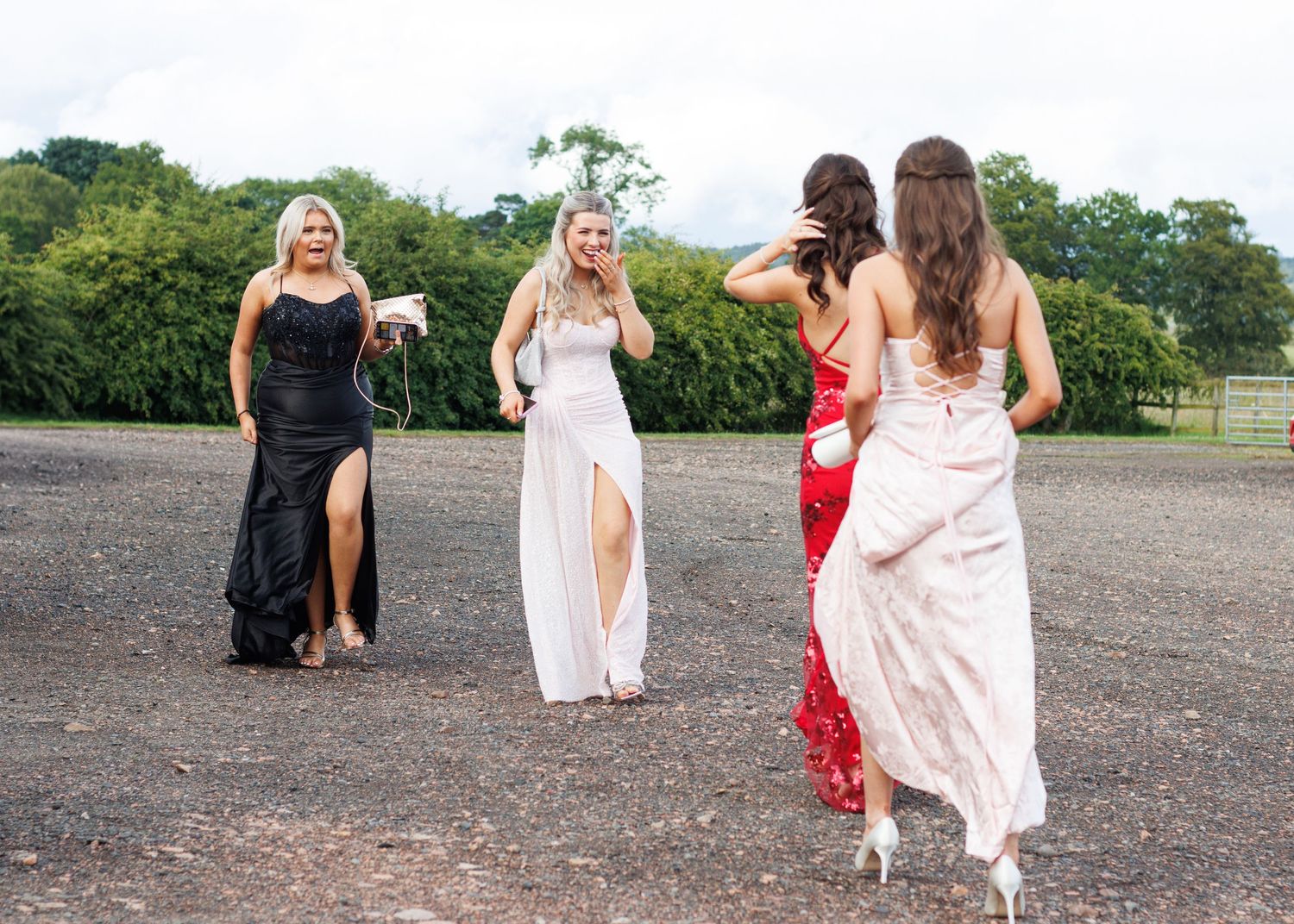 Group walks together on a gravel path during a summer outdoor photoshoot.