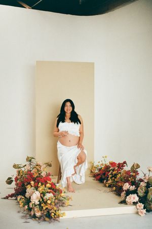 A series of minimalist artistic portraits with decorative floral arrangements against a simple cream-colored backdrop.