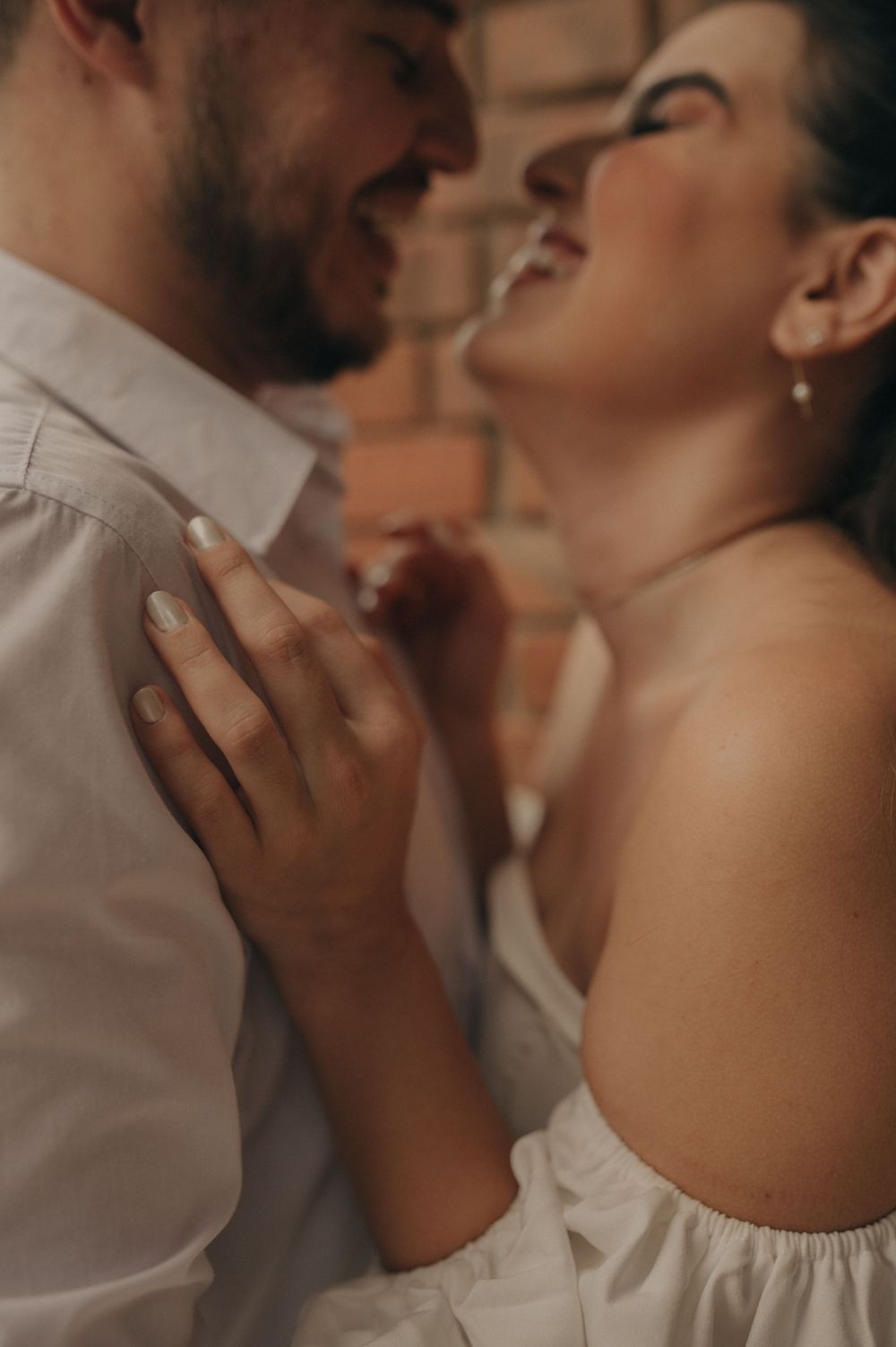 A romantic close-up moment between a couple sharing an intimate laugh together.