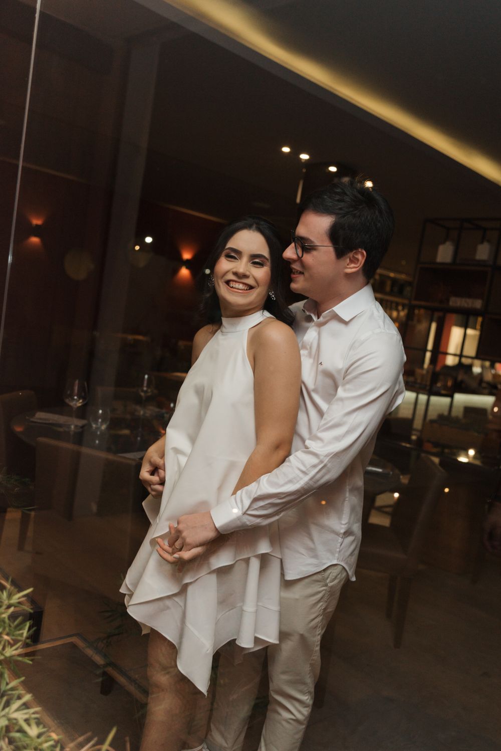 Couple dancing and laughing together in an elegant indoor setting.