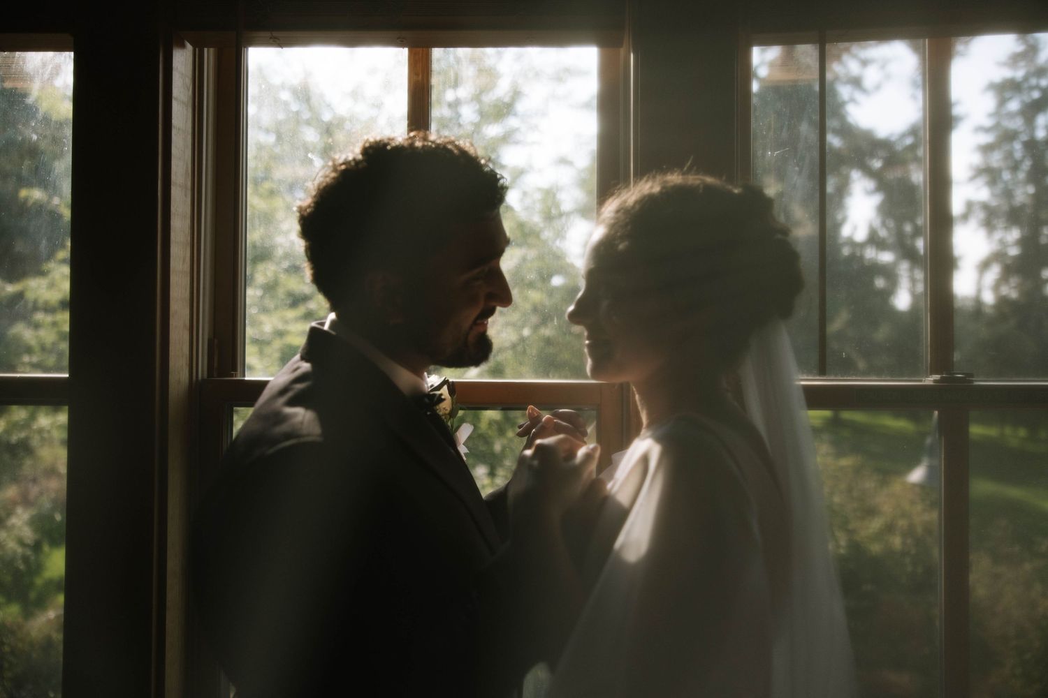 Silhouetted figures in window frames creating dramatic lighting effect.