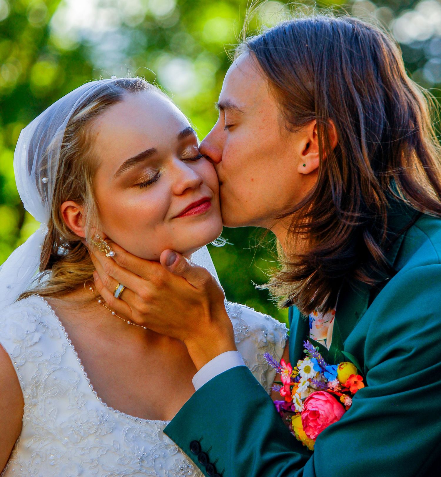 A just-married couple kisses on a vintage car surrounded by dazzling sparkler fountains at night.