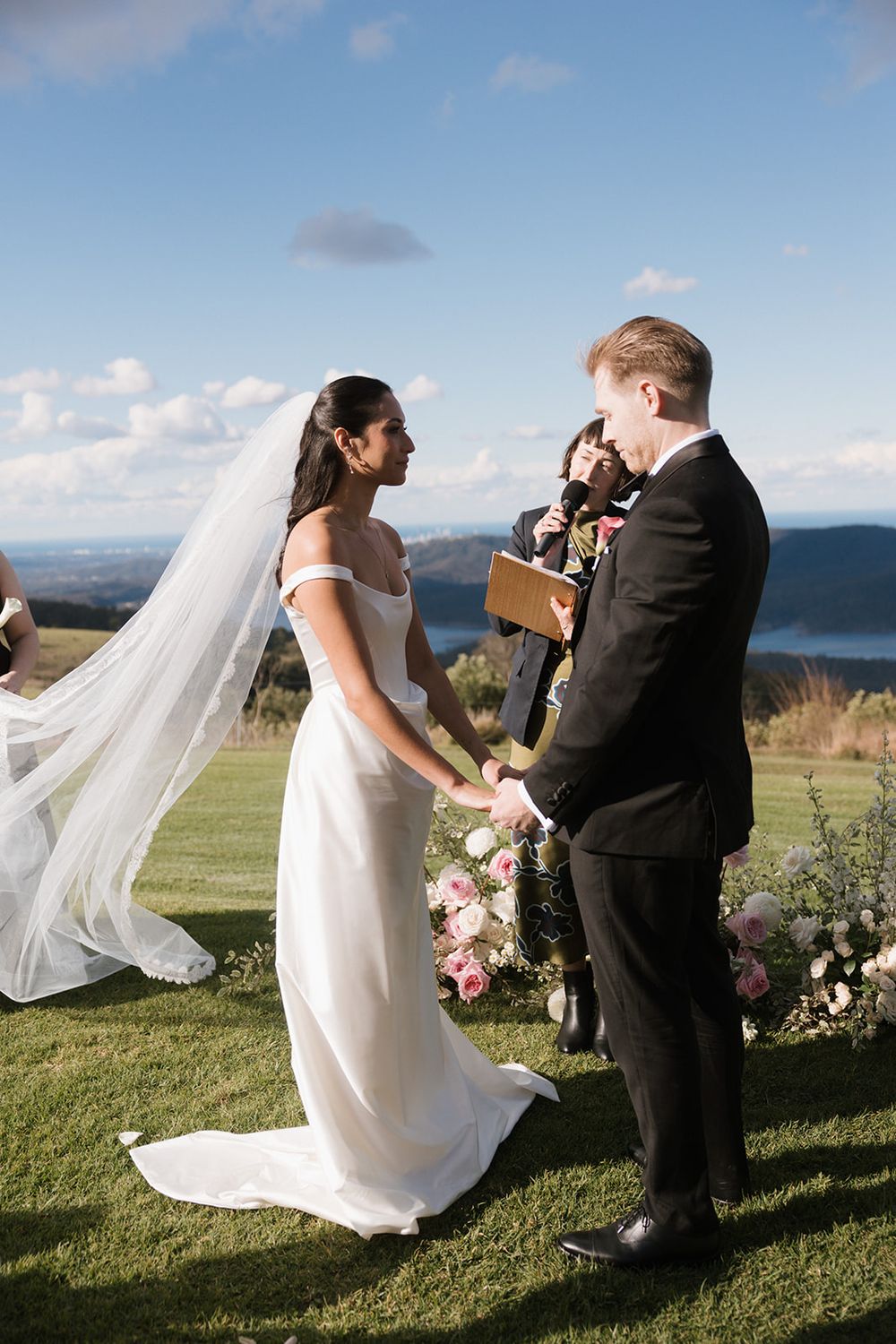 Elegant outdoor wedding ceremony overlooking a scenic mountain vista with floral arrangements.