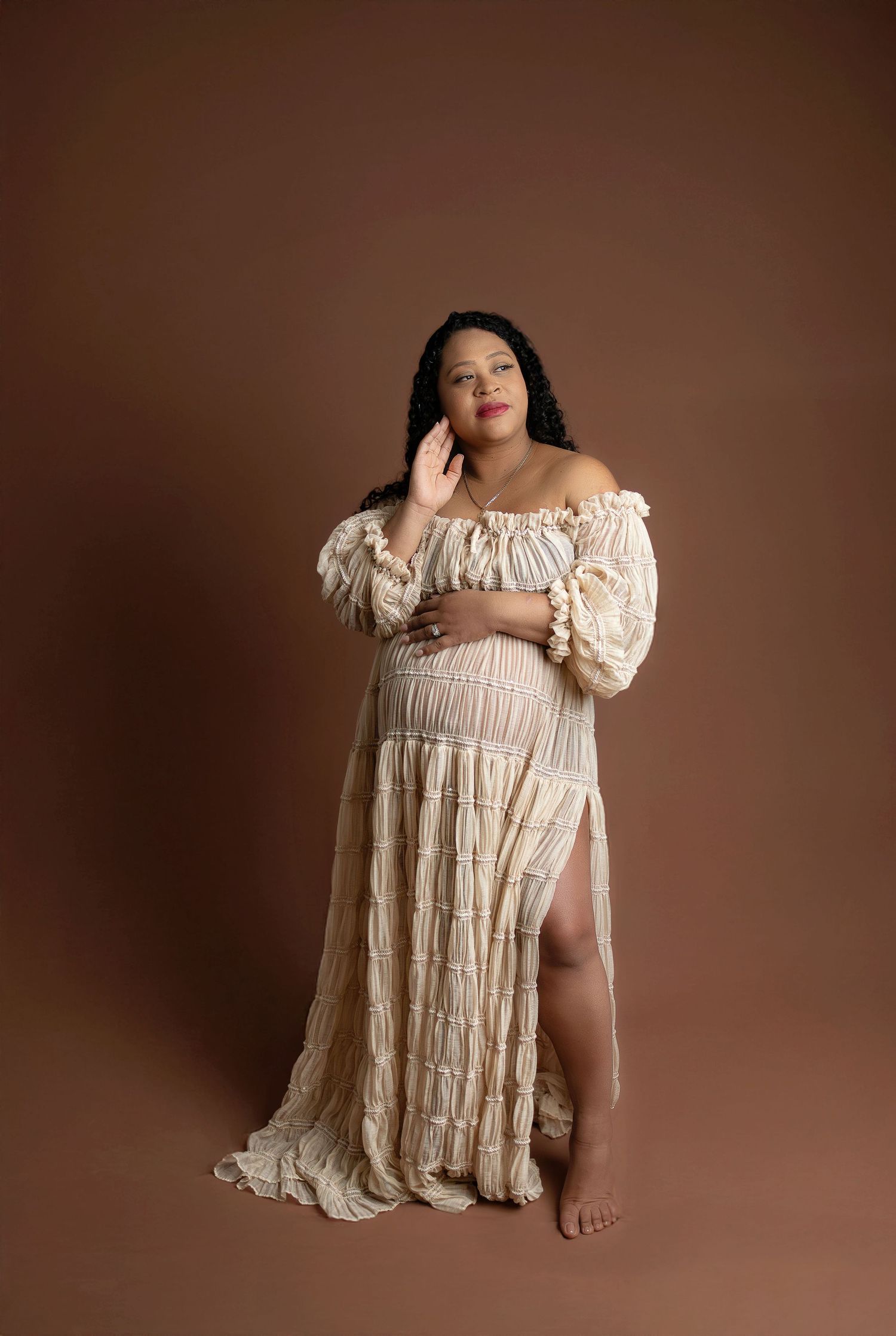 A vintage-inspired lace wedding dress with empire waist and flowy train displayed on a cream mannequin form.