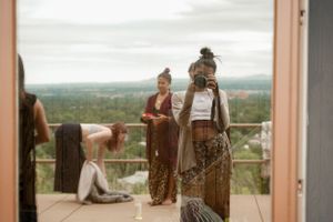 People gathered on a deck overlooking a vast forest landscape on a cloudy day.