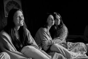 Friends enjoying a cozy slumber party together in black and white.