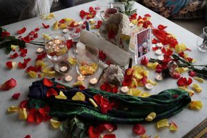 Romantic table setting with scattered rose petals and decorative elements.