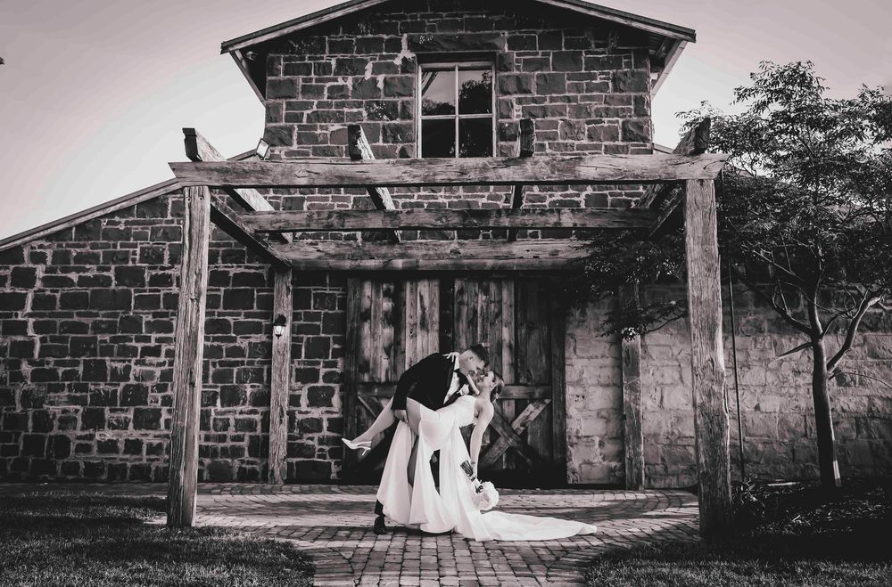 Newlyweds walking hand in hand after ceremony with barn behind