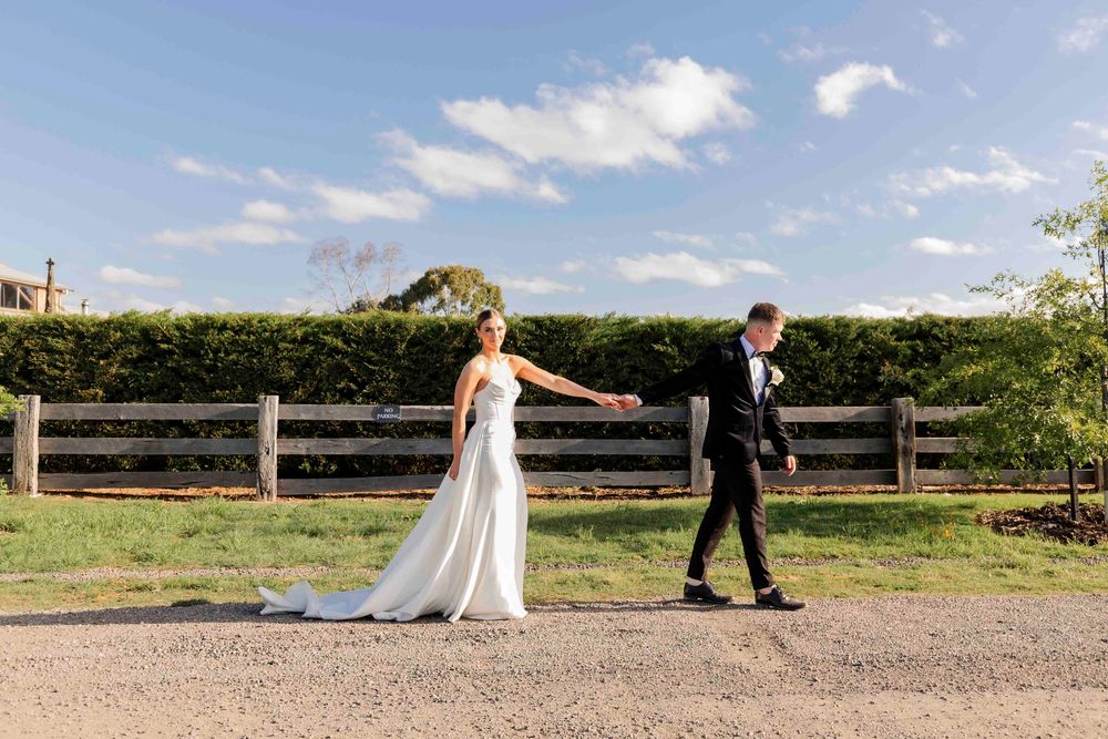 Newlyweds walking hand in hand after ceremony with valley views behind