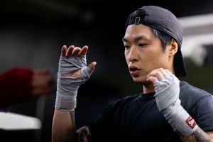 Athletes practicing martial arts moves in an indoor training facility.