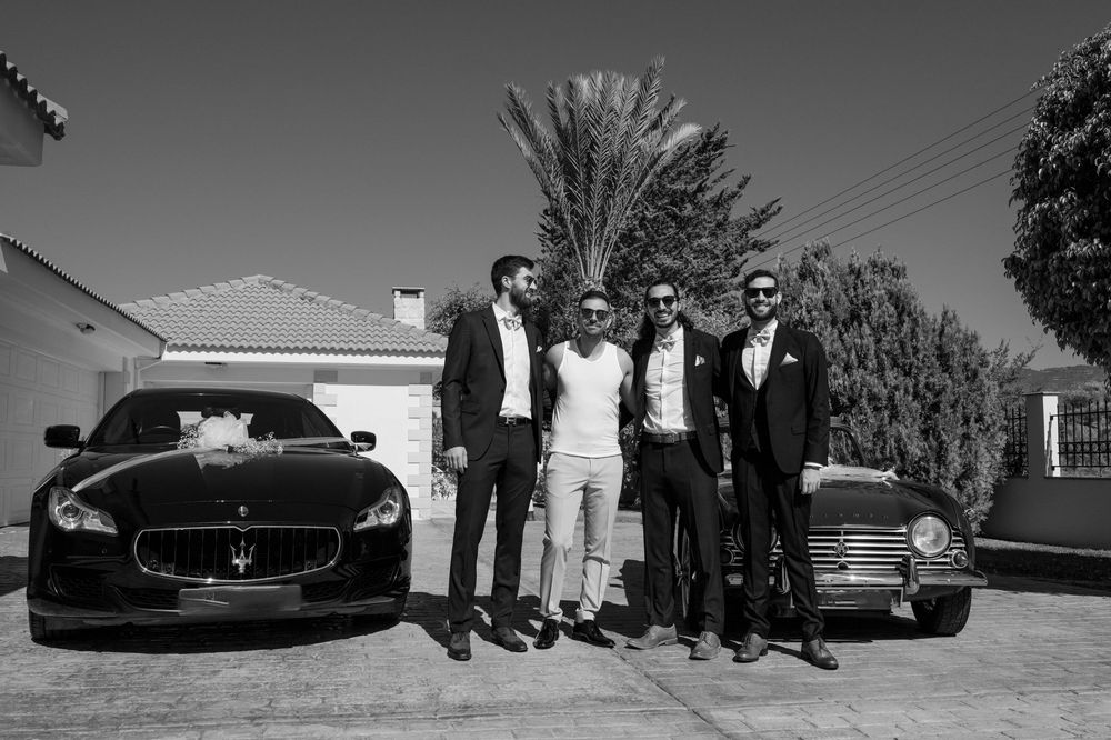 Row of luxury cars including Maserati and other high-end vehicles lined up for photo shoot against residential backdrop.