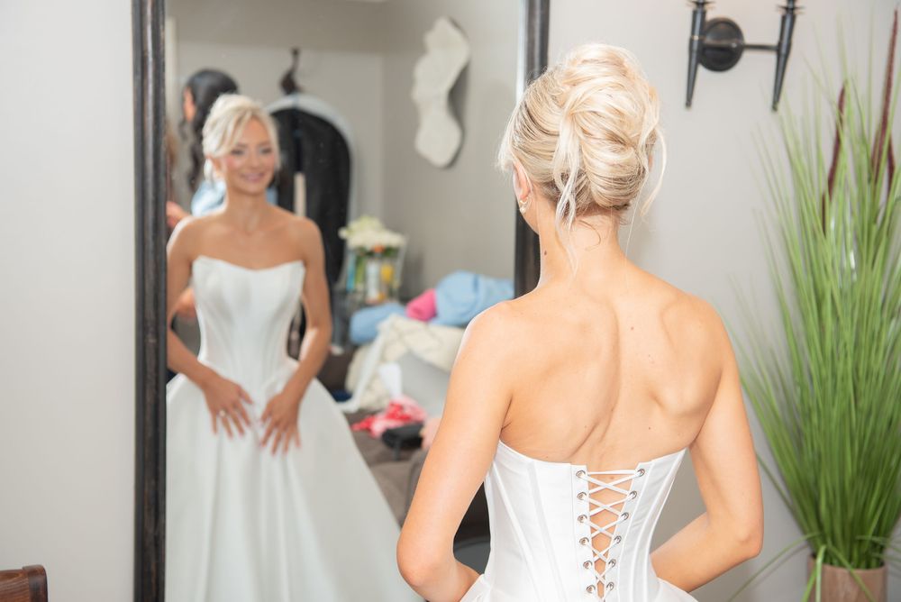 Close-up details of a white wedding dress with corset-style lacing in the back.
