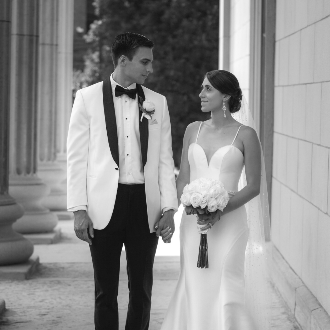 Elegant wedding couple takes romantic photos along classic white columns.