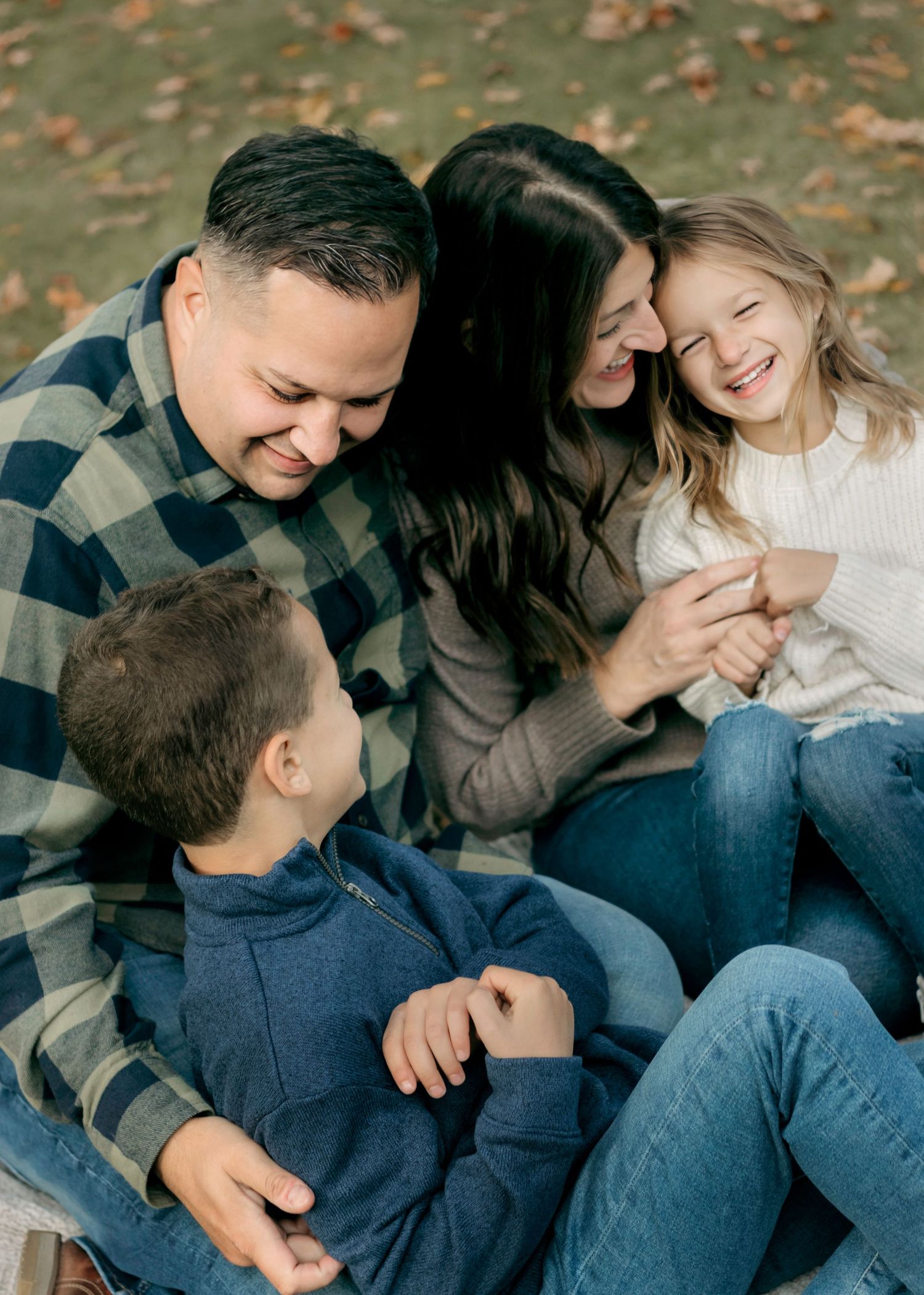 Candid family moment with everyone laughing together on couch.